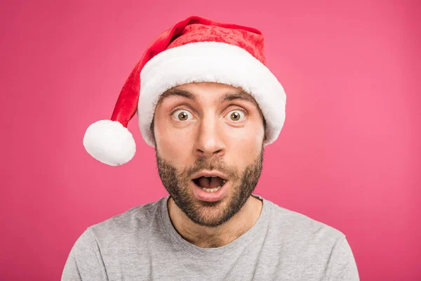 Portrait of shocked man in santa hat, isolated on pink — Stock Photo