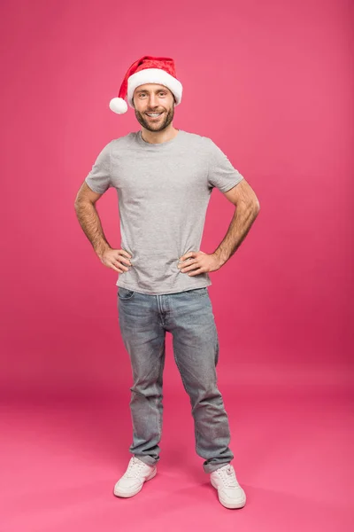Portrait of happy man in santa hat at christmastime, isolated on pink — Stock Photo
