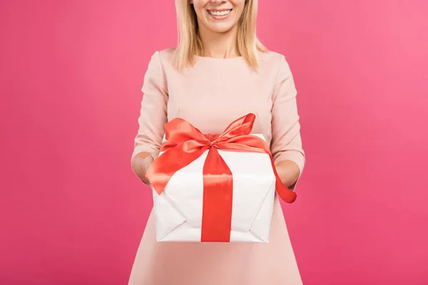 Vista recortada de la mujer sosteniendo caja de regalo aislado en rosa - foto de stock