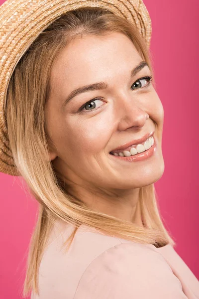 Atractiva mujer rubia en sombrero de paja, aislado en rosa - foto de stock