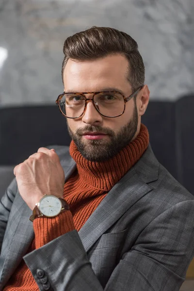 Retrato de hombre guapo en ropa formal y gafas mirando a la cámara - foto de stock