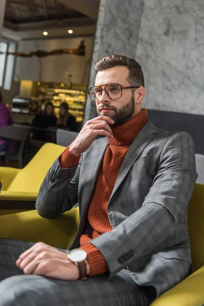 Handsome pensive man in formal wear and glasses sitting in restaurant — Stock Photo