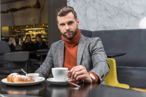 Schöner Mann in formeller Kleidung, der beim Mittagessen im Restaurant in die Kamera schaut — Stockfoto