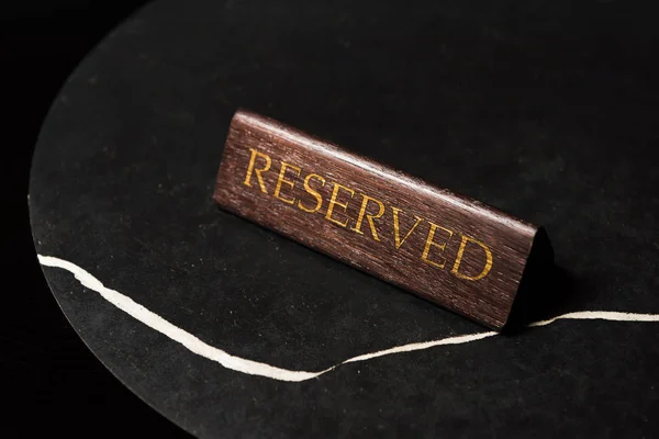 Reserved sign on black table in cafe with copy space — Stock Photo