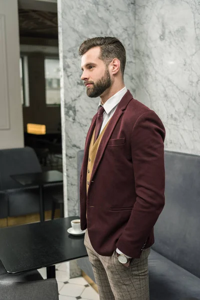 Uomo d'affari fiducioso in abbigliamento formale con mano in tasca guardando altrove — Foto stock
