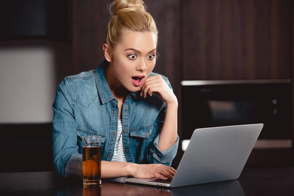 Ragazza stupita guardando lo schermo del computer portatile a casa — Foto stock