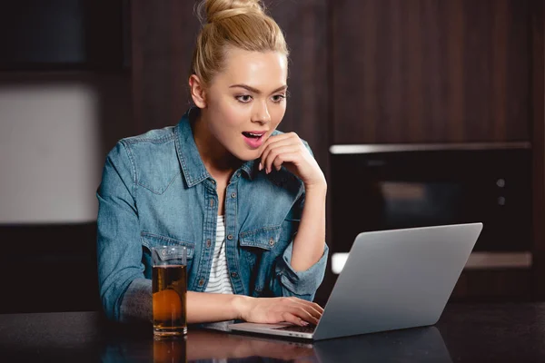 Ragazza sorpresa guardando lo schermo del computer portatile a casa — Foto stock