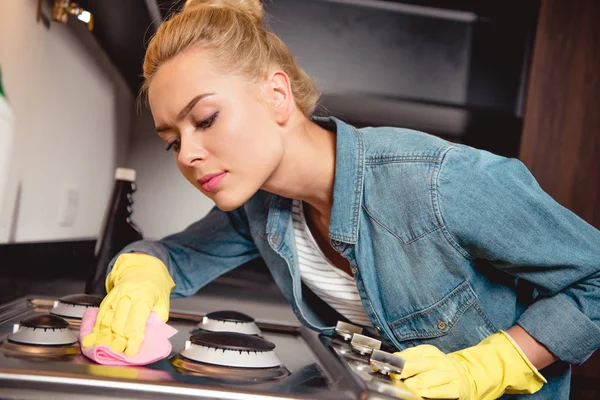 Attractive girl in rubber gloves cleaning kitchen — Stock Photo