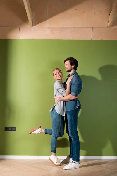 Bonito homem e alegre menina abraçando no apartamento — Fotografia de Stock