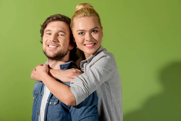 Attraktives Mädchen umarmt schönen Mann auf grünem Hintergrund — Stockfoto