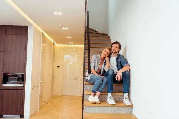 Couple aimant assis sur les escaliers à la maison — Photo de stock