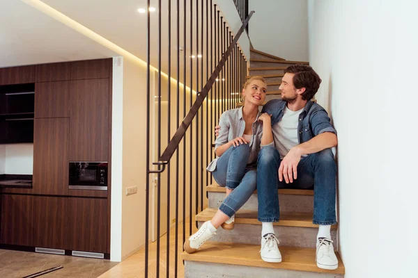Loving couple sitting on stairs and looking at each other — Stock Photo