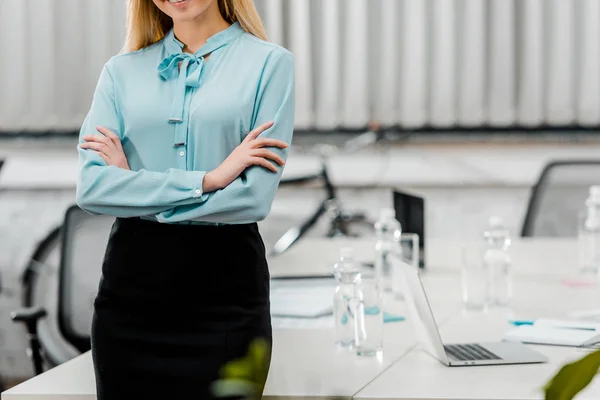 Обрізаний знімок бізнес-леді в офіційному одязі з обіймами, схрещеними в офісі — Stock Photo