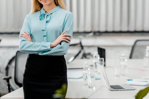 Ritagliato colpo di donna d'affari in abbigliamento formale con le braccia incrociate in ufficio — Foto stock