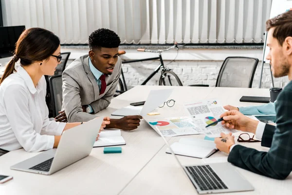 Grupo de empresários multiétnicos que discutem durante reunião no escritório — Fotografia de Stock