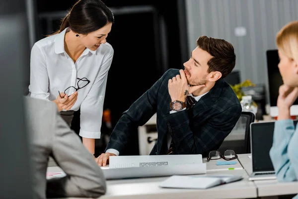 Partial view of businesspeople having conversation at workplace with papers in office — Stock Photo