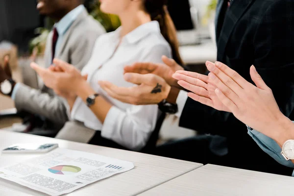 Point de vue partiel des gens d'affaires multiraciaux applaudissant à l'orateur au bureau — Photo de stock