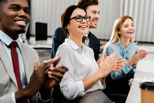 Smiling multiracial businesspeople applauding to speaker in office — Stock Photo
