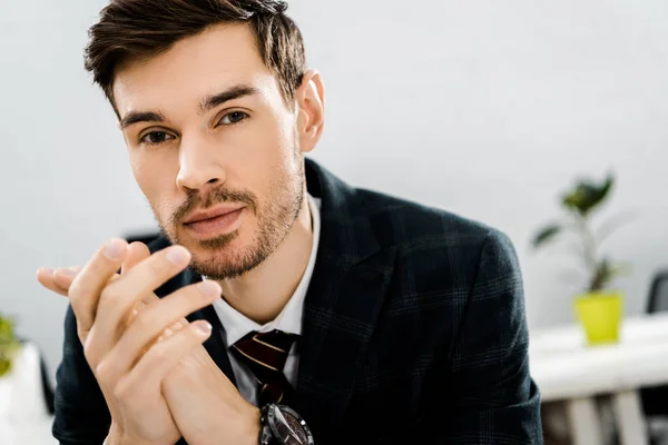 Porträt eines nachdenklichen Geschäftsmannes im Anzug, der im Büro in die Kamera blickt — Stockfoto