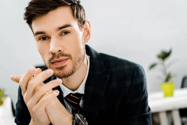 Portrait d'homme d'affaires réfléchi en costume regardant la caméra dans le bureau — Photo de stock