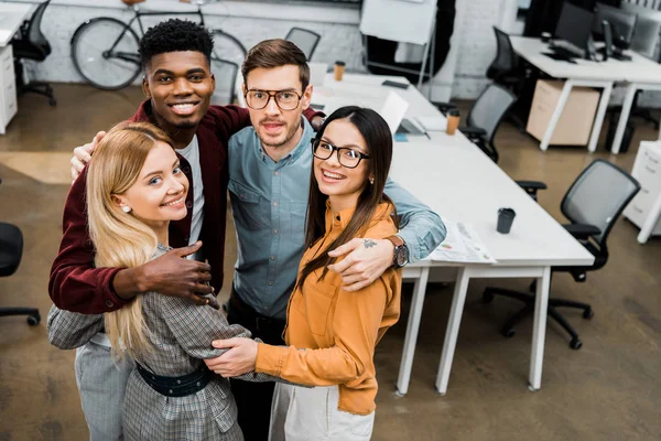 High angle view of multiethnic happy business colleagues looking at camera in office — Stock Photo