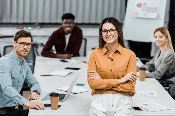 Jóvenes empresarios multirraciales mirando a la cámara en la oficina - foto de stock