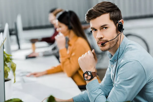 Selective focus of call center operator in headset in office — Stock Photo