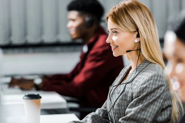 Selektiver Fokus eines lächelnden Callcenter-Betreibers im Büro — Stockfoto