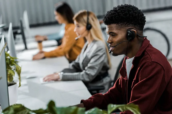 Opérateurs de centres d'appels multiculturels avec écouteurs à workpalce au bureau — Photo de stock