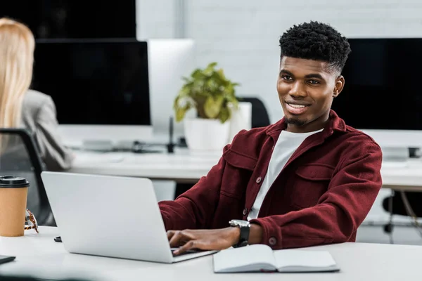 Jovem empresário afro-americano no local de trabalho com laptop no escritório — Fotografia de Stock
