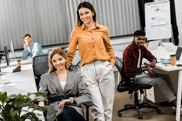 Jóvenes sonrientes colegas de negocios multirraciales en el cargo - foto de stock