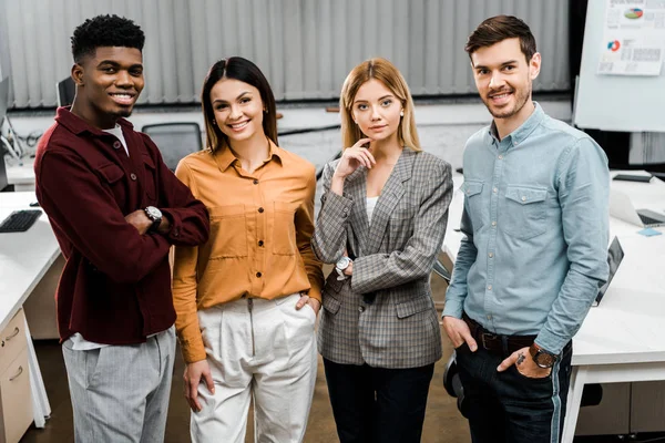 Retrato de jóvenes colegas de negocios multirraciales sonrientes en el cargo - foto de stock