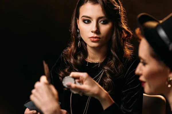 Selective focus of attractive girls playing poker in casino — Stock Photo