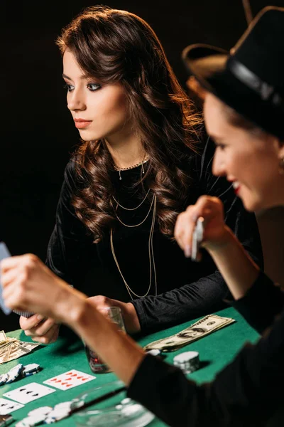 Mulheres bonitas jogando poker com cartas e fichas na mesa no cassino — Fotografia de Stock