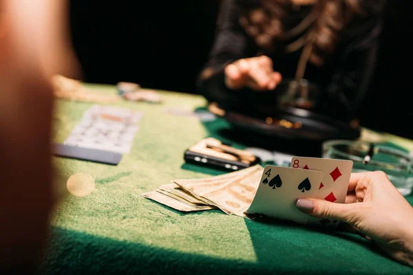 Imagen recortada de las niñas jugando póquer en la mesa en el casino - foto de stock