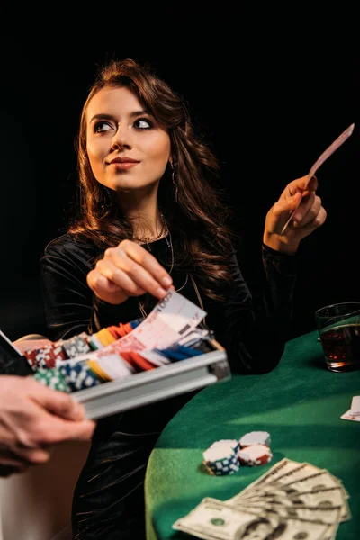Schöne fröhliche Frau nimmt Euro-Banknoten aus Schachtel am Tisch im Casino — Stockfoto