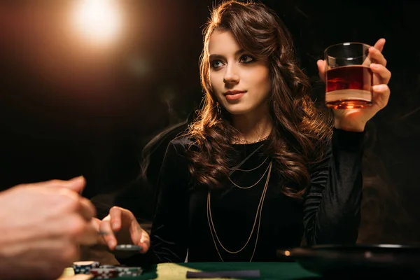 Blick auf ein attraktives Mädchen mit einem Glas Whiskey am Pokertisch im Casino — Stockfoto