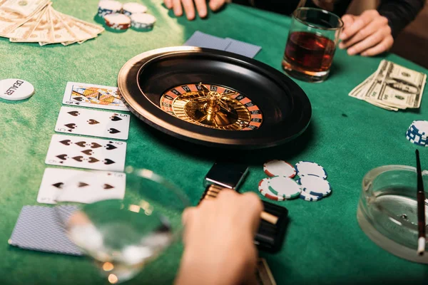 Обрезанный образ девушек, играющих в рулетку за покерным столом в казино — стоковое фото