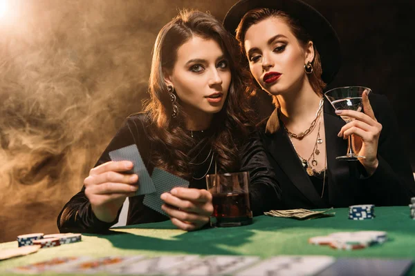 Attractive girls playing poker at table in casino — Stock Photo