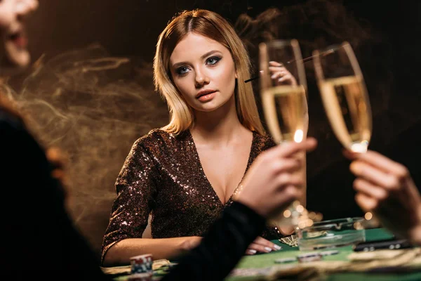 Girls clinking with glasses of champagne at poker table in casino — Stock Photo