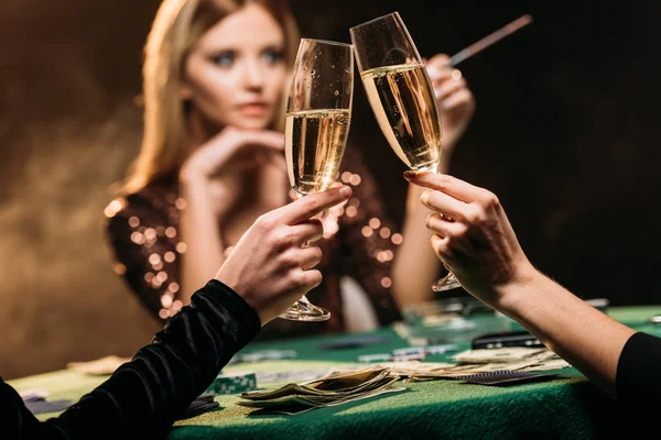 Foyer sélectif de jolies filles cliquetis avec des verres de champagne à la table de poker au casino — Photo de stock