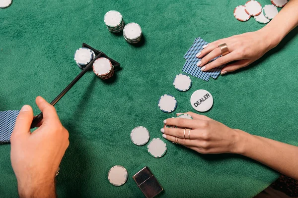 Обрізане зображення жінки та крокера, що грає в покер за столом у казино — стокове фото