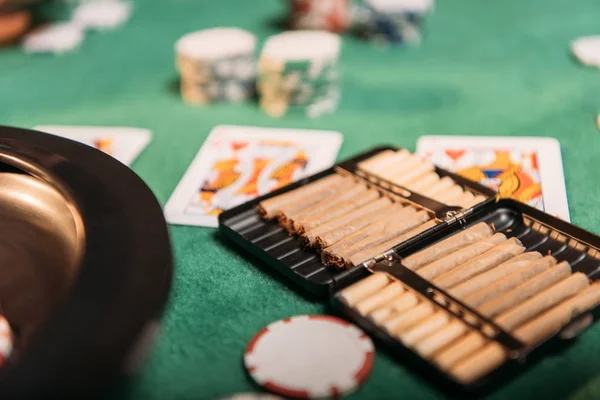 Рулетка, сигары и покер карты на столе в казино — стоковое фото