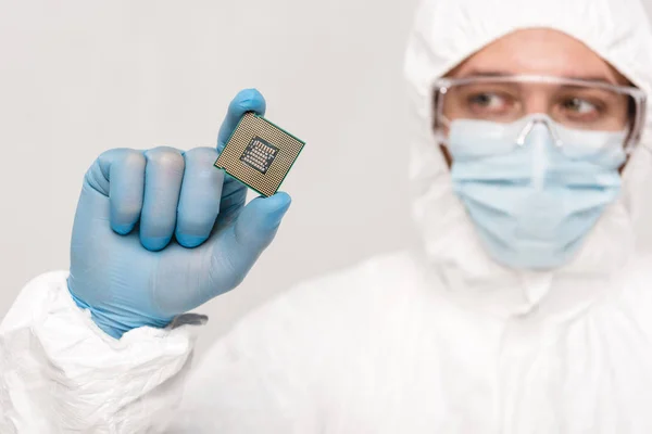 Selective focus of microchip in hand of scientist in googles isolated on grey — Stock Photo