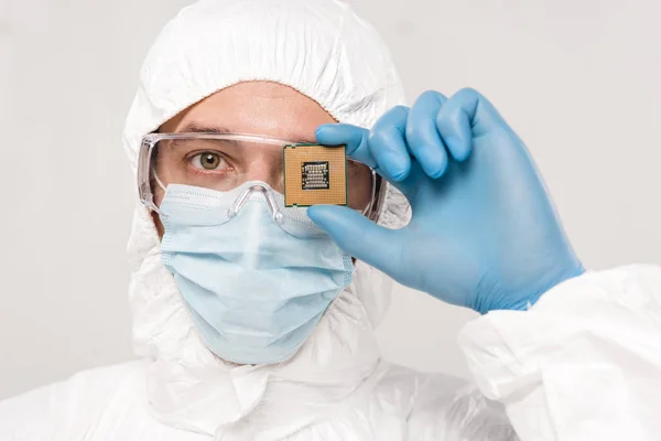 Scientist in googles holding microchip in hand isolated on grey — Stock Photo