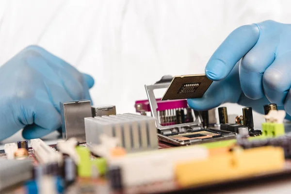 Visão cortada de microchip em mãos de cientista em luvas de látex — Fotografia de Stock