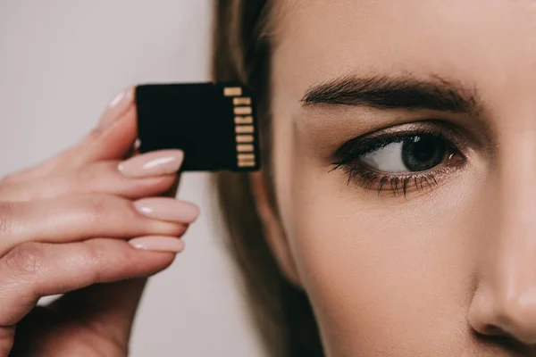 Cropped view of microchip near eye in hand of woman — Stock Photo