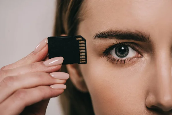 Vista cortada da mulher segurando microchip na mão perto do olho — Fotografia de Stock