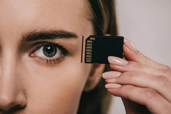 Cropped view of woman holding microchip while inserting in head — Stock Photo