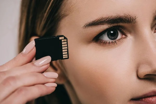 Vista cortada de microchip perto do olho na mão feminina — Fotografia de Stock